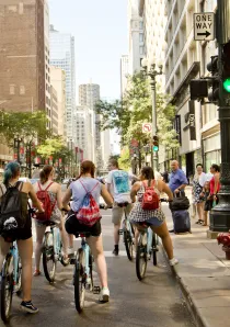 cyclists and pedestrians wait at street crossing in downtown Chicago