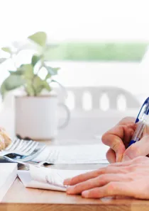 person signing a lease agreement form on a wooden desk in a Chicago apartment