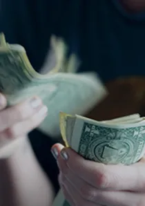 apartment renter counting US dollar bills by hand