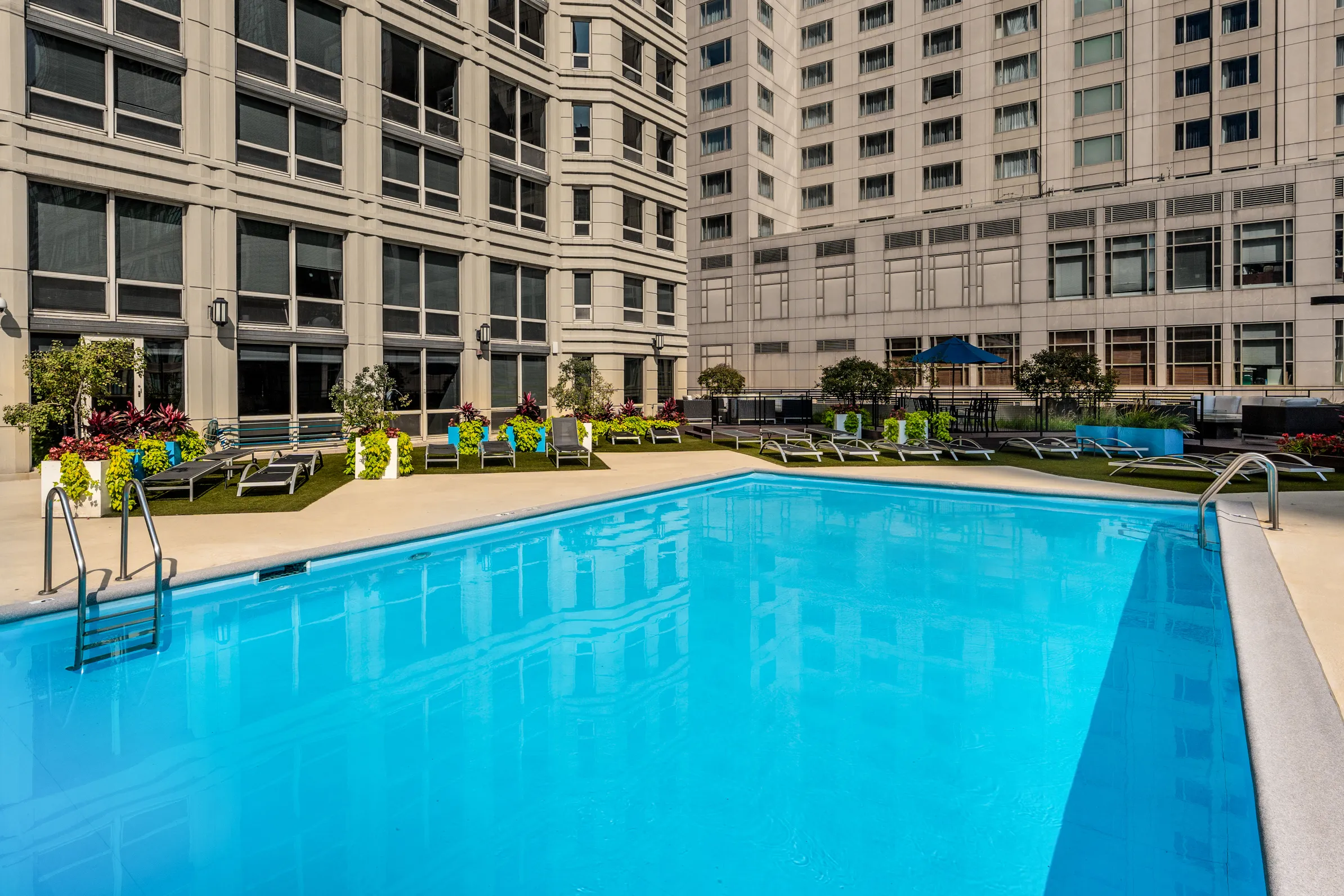 750 North Rush Apartments outdoor Swimming Pool with garden and chairs