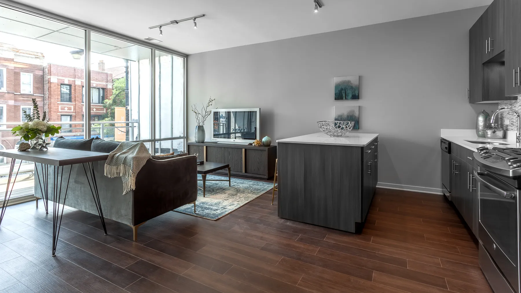 kitchen island with stool and couch at Luxe On Chicago Apartments