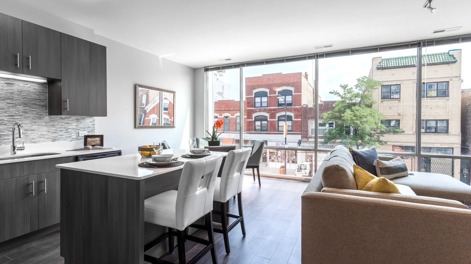 kitchen island with stool and couch at Luxe On Chicago Apartments