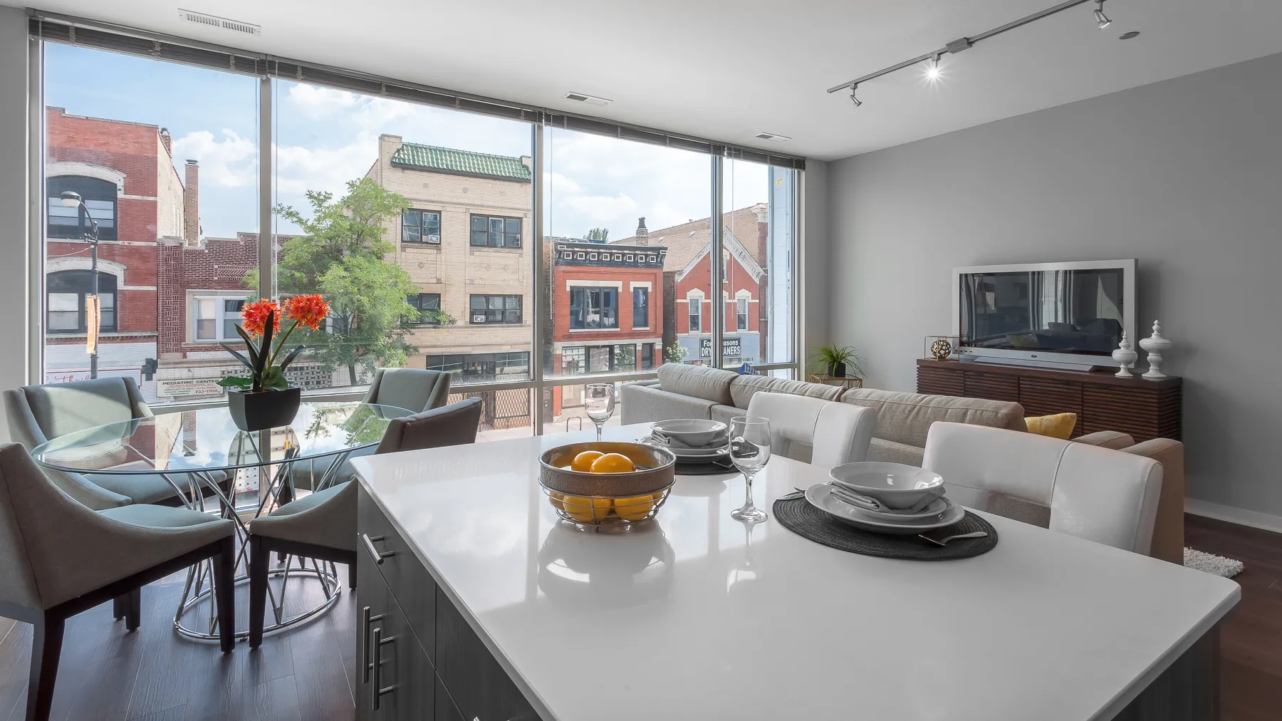 kitchen island with stool and couch at Luxe On Chicago Apartments