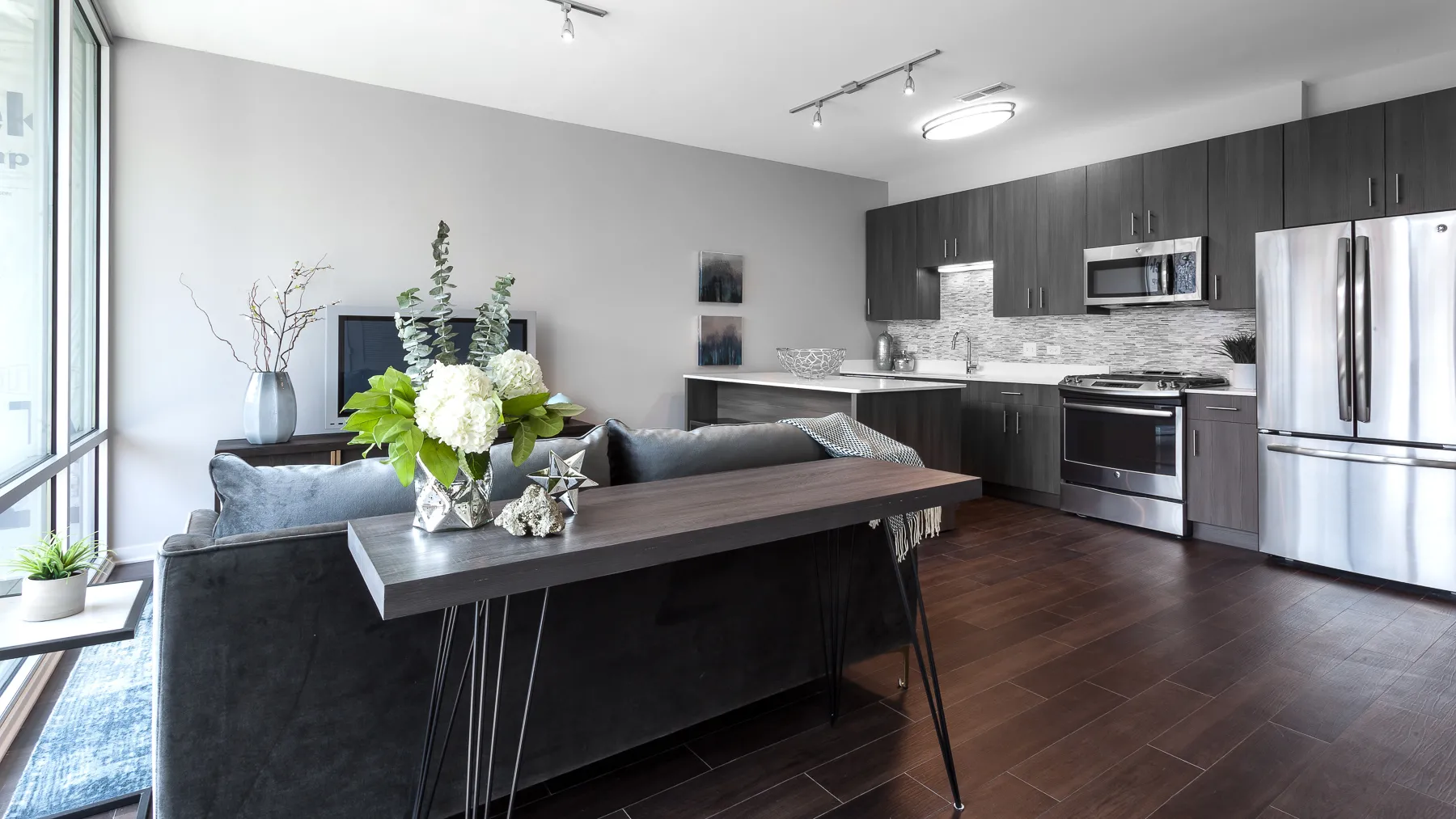 kitchen island with stool and couch at Luxe On Chicago Apartments