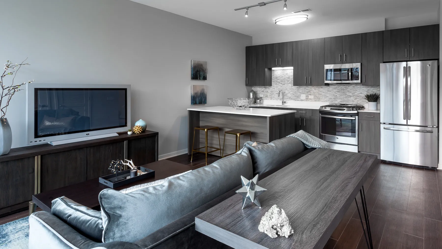 kitchen island with stool and couch at Luxe On Chicago Apartments