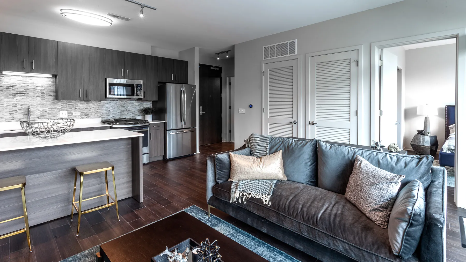 kitchen island with stool and couch at Luxe On Chicago Apartments