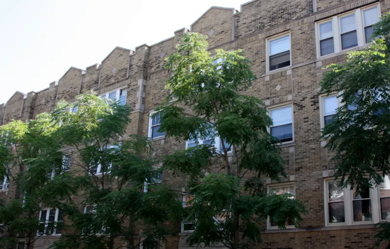 tress and brick front of 4551-4553 N Claremont Apartments