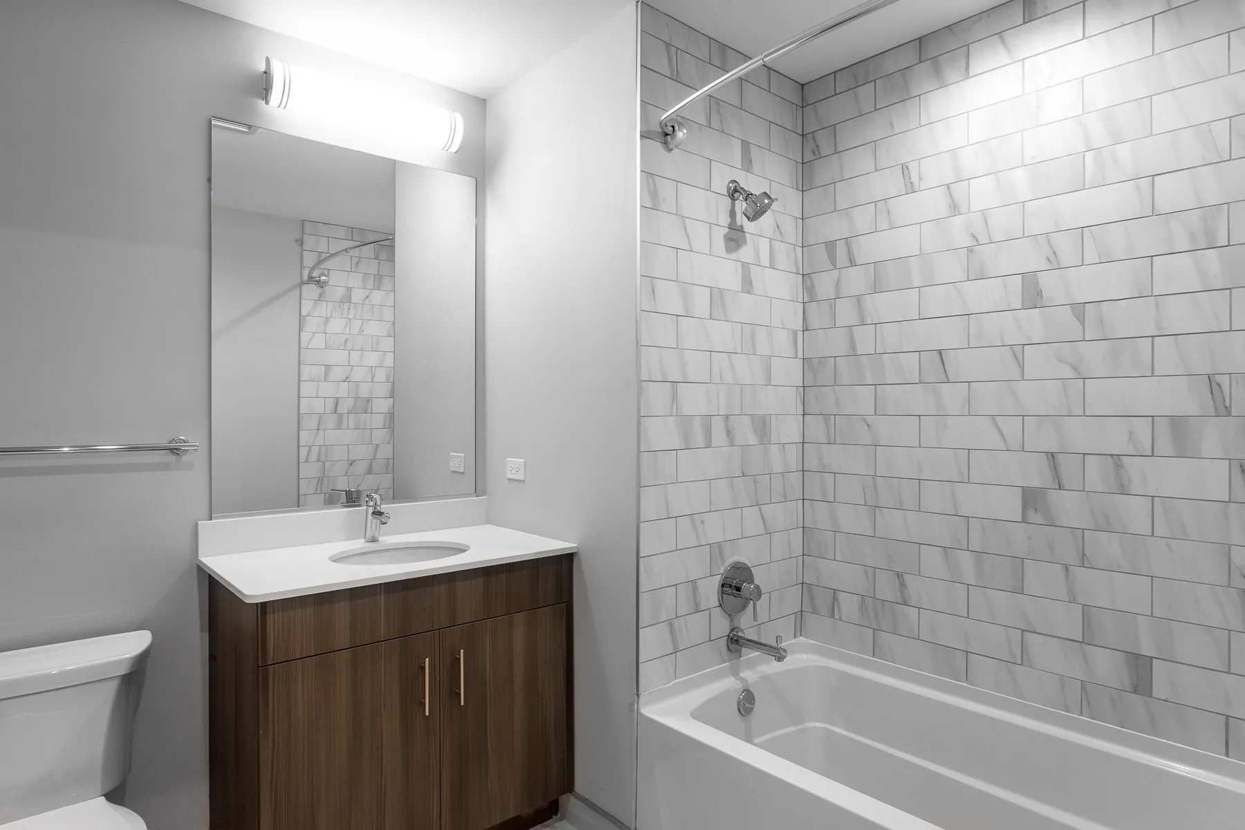 kitchen island with stool and couch at Luxe On Chicago Apartments