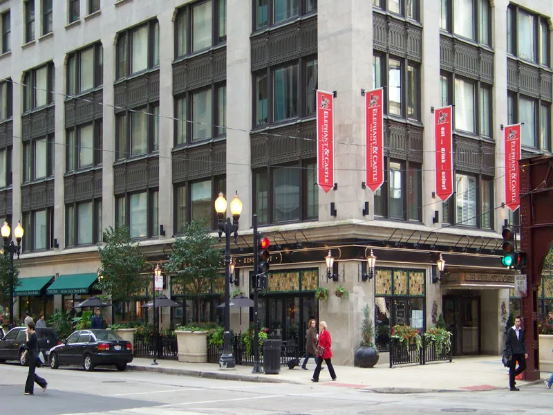 entrance to MDA City Club Apartments with red bench a flowers in pot