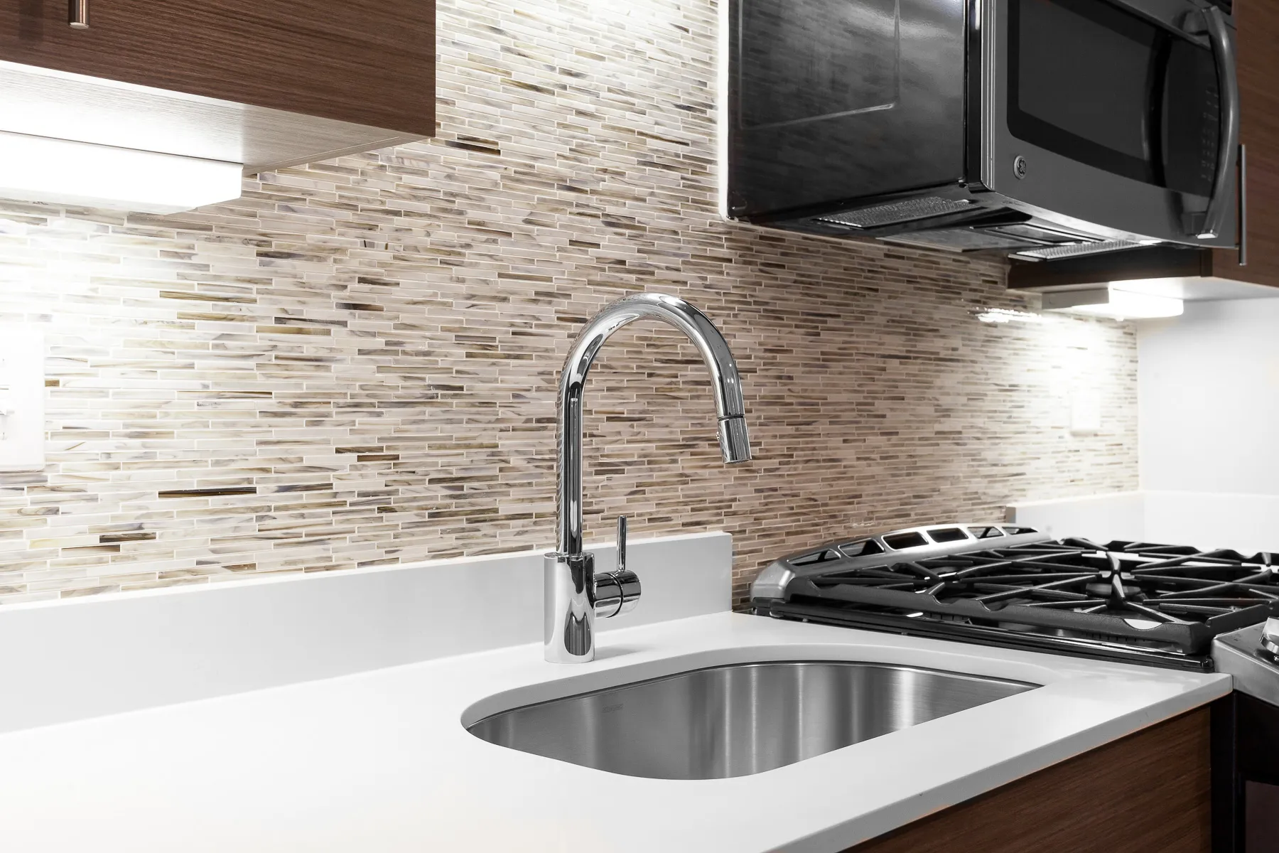 kitchen island with stool and couch at Luxe On Chicago Apartments