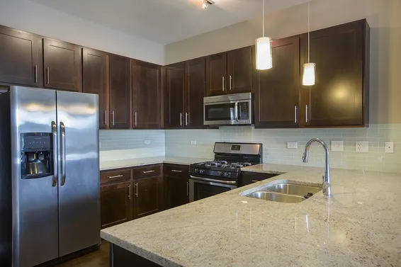 modern kitchen with brown wood cabints at The Shelby Apartments in Chicago