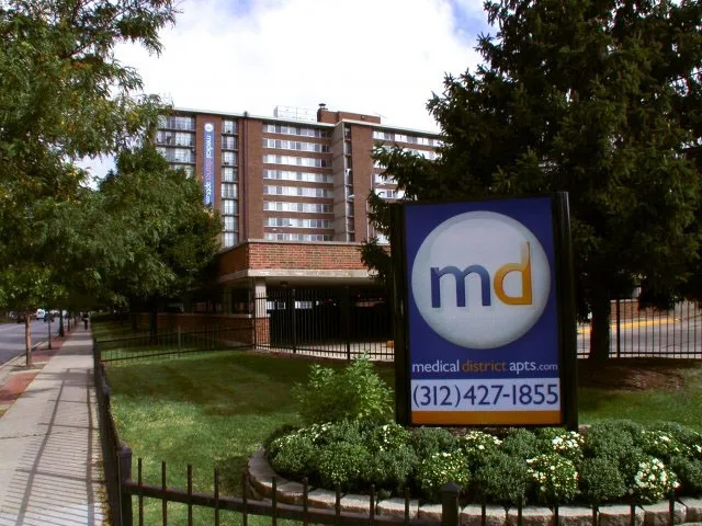 model bedroom with green wall at SCIO at the Medical District Apartments