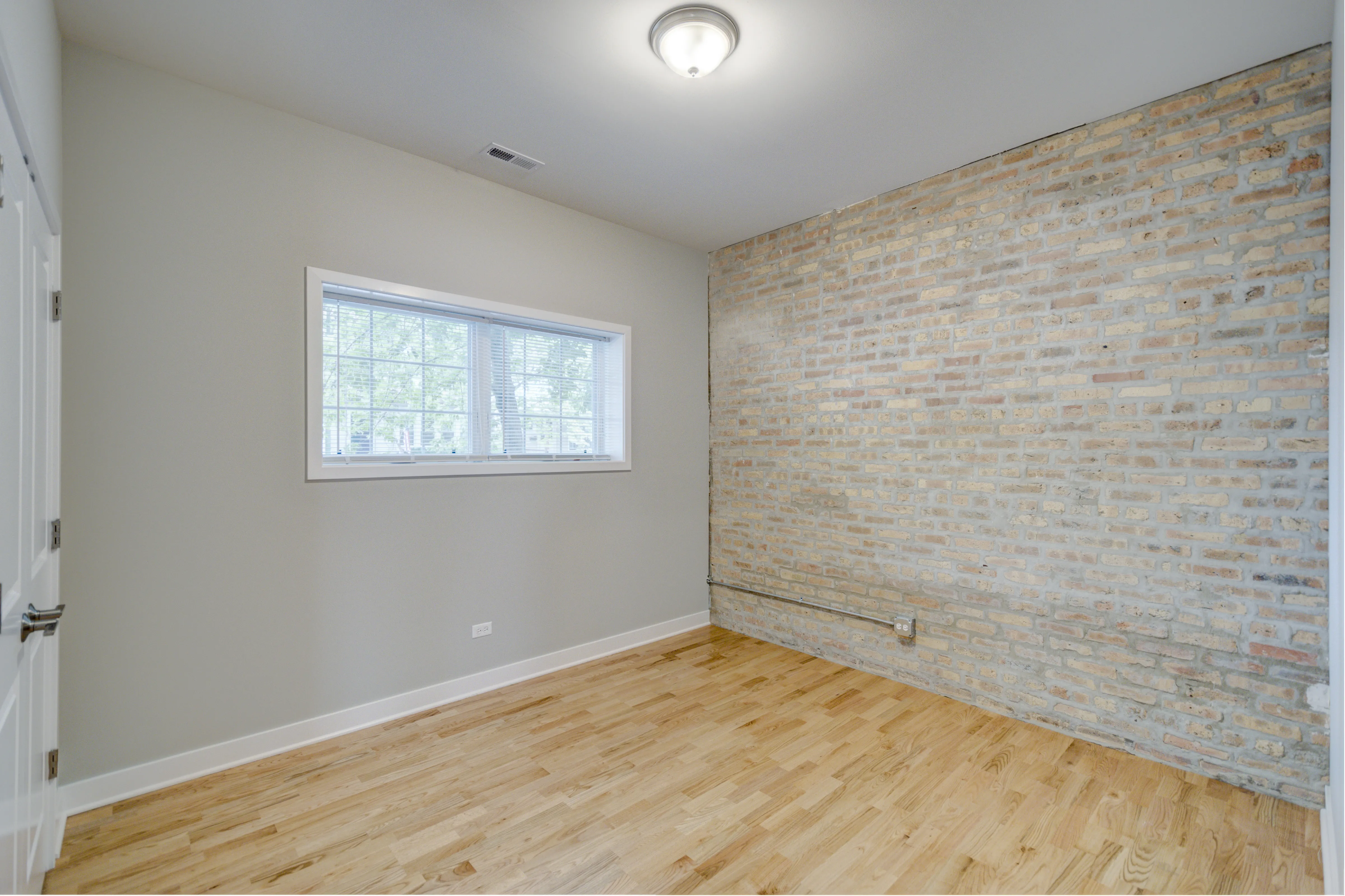 empty model living room with wood floors at 6125 North Clark Apartments
