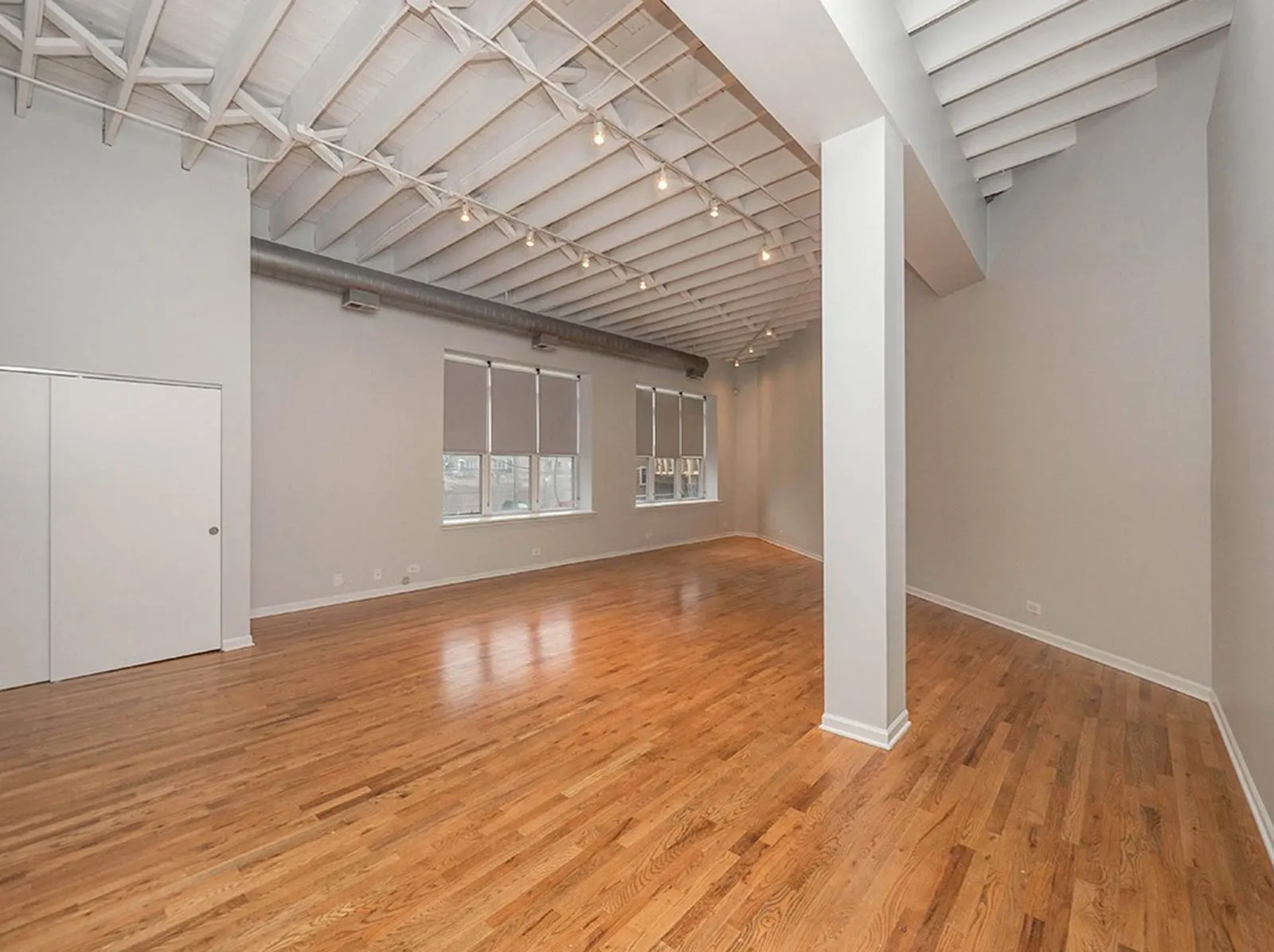giant loft living room with wood floors at 1550 North Damen Lofts