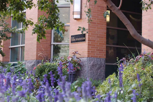 flowers surround the entrance of The Park Evanston Apartments in Evanston