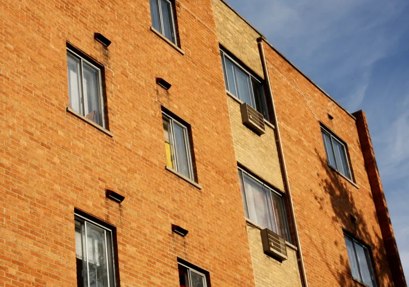 looking up at brick and windows at 5841 North Winthrop Apartments