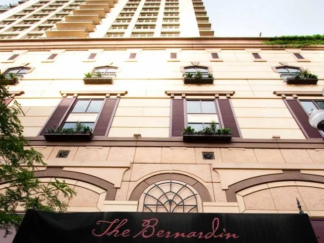 view looking up at The Bernardin Apartments with car traffic
