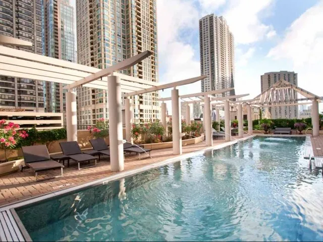 view looking up at The Bernardin Apartments with car traffic