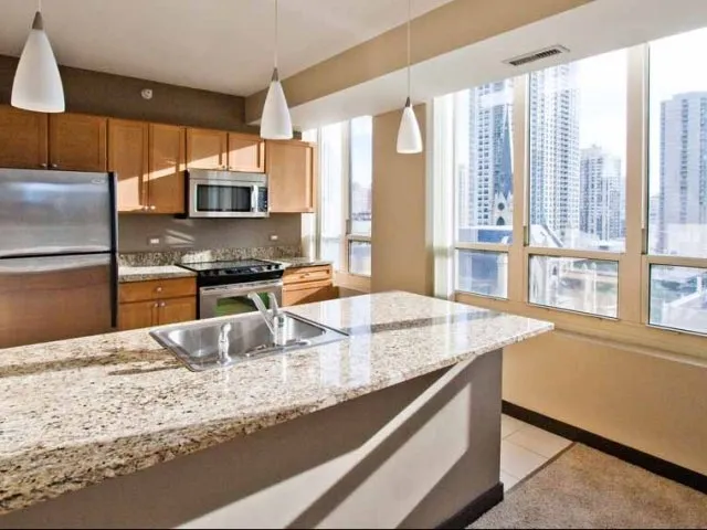 view looking up at The Bernardin Apartments with car traffic