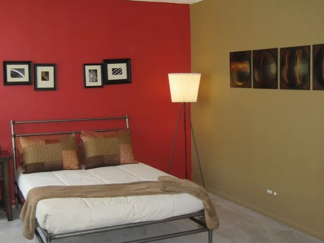 model bedroom with green wall at SCIO at the Medical District Apartments