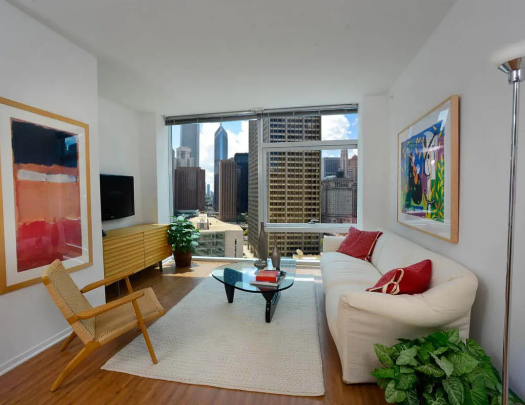 living room with wood floors and downtown view at Aston Chicago Apartments