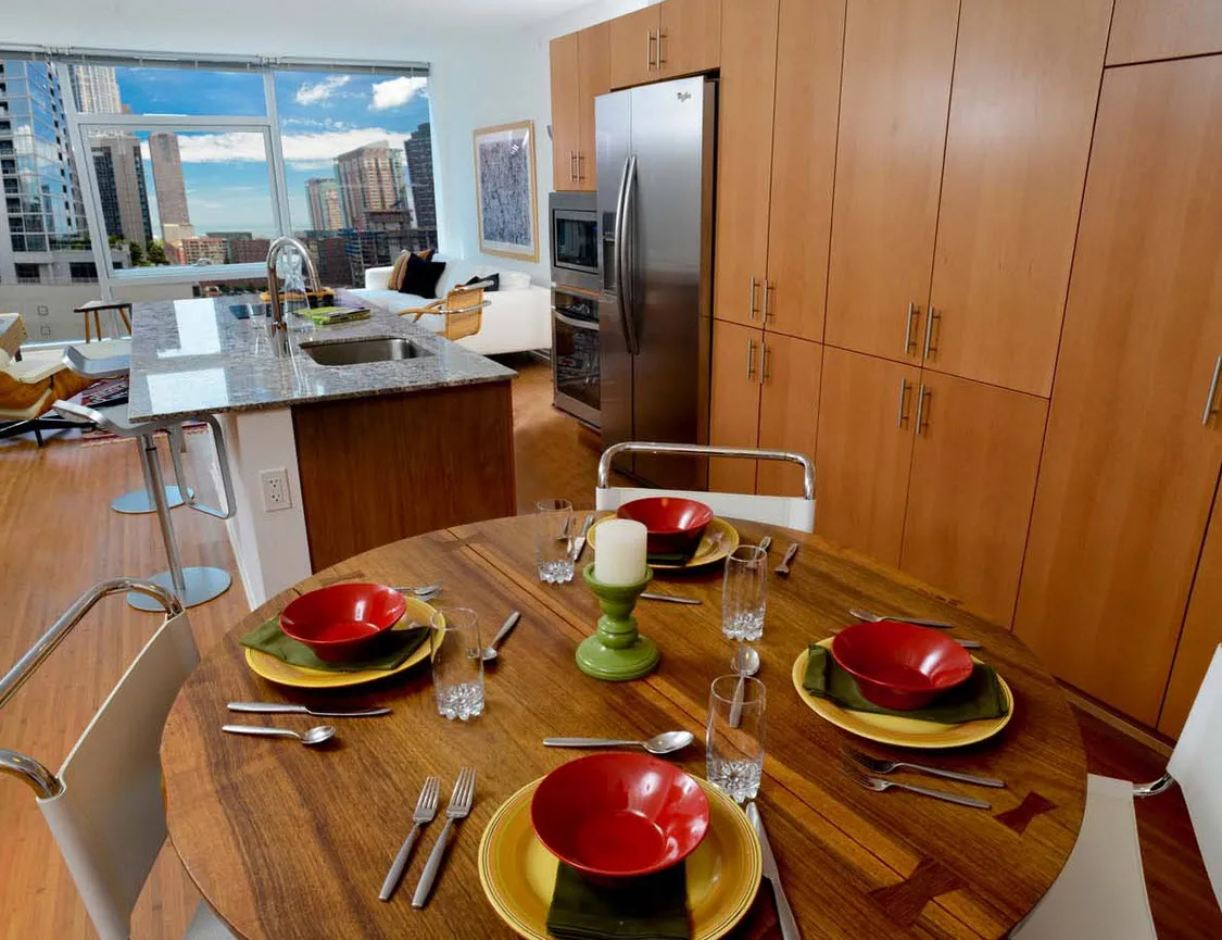 living room with wood floors and downtown view at Aston Chicago Apartments