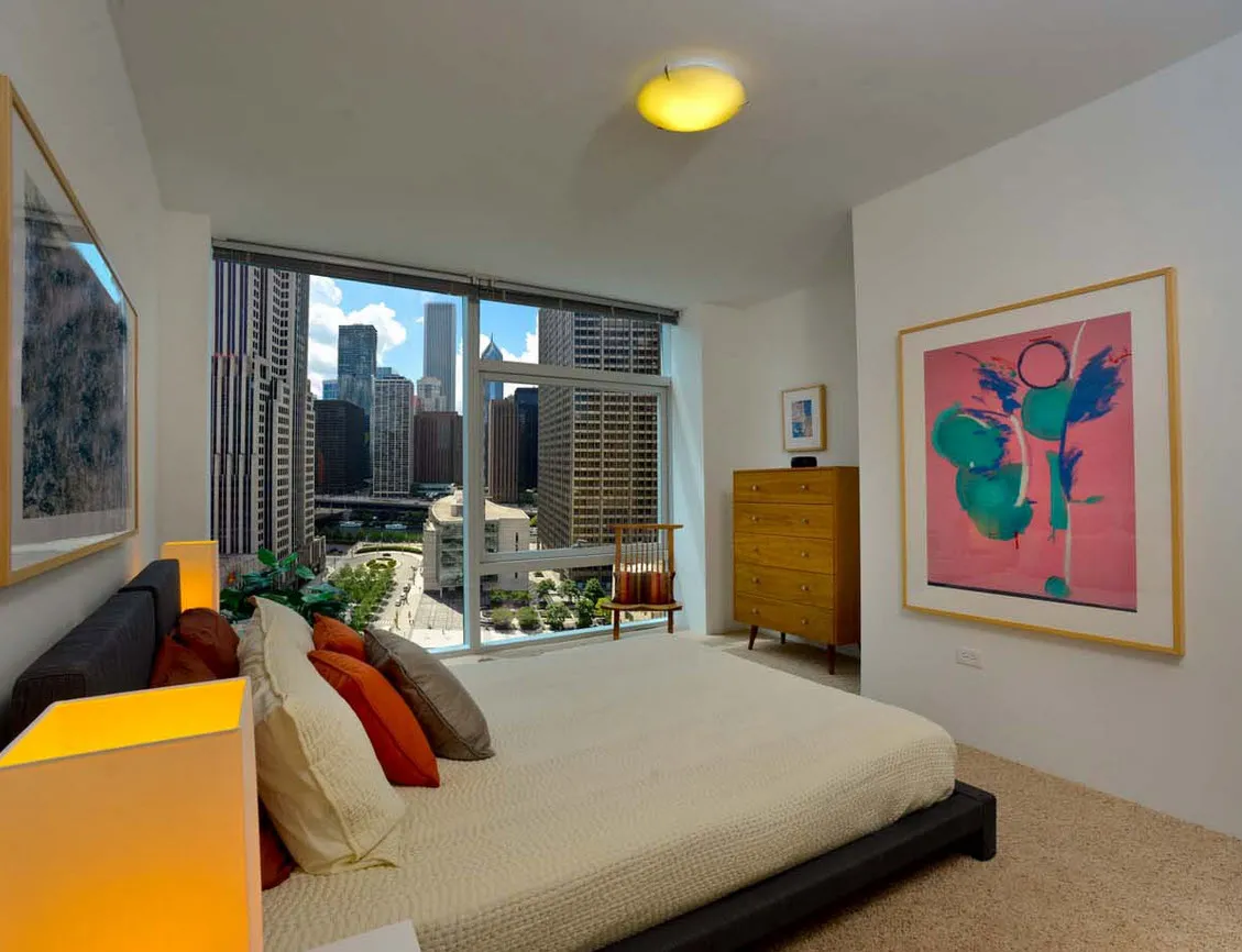 living room with wood floors and downtown view at Aston Chicago Apartments