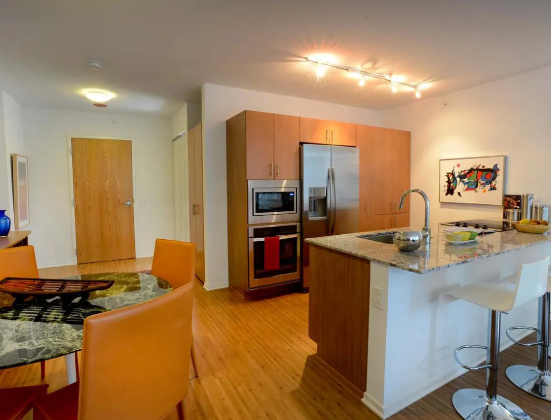 living room with wood floors and downtown view at Aston Chicago Apartments