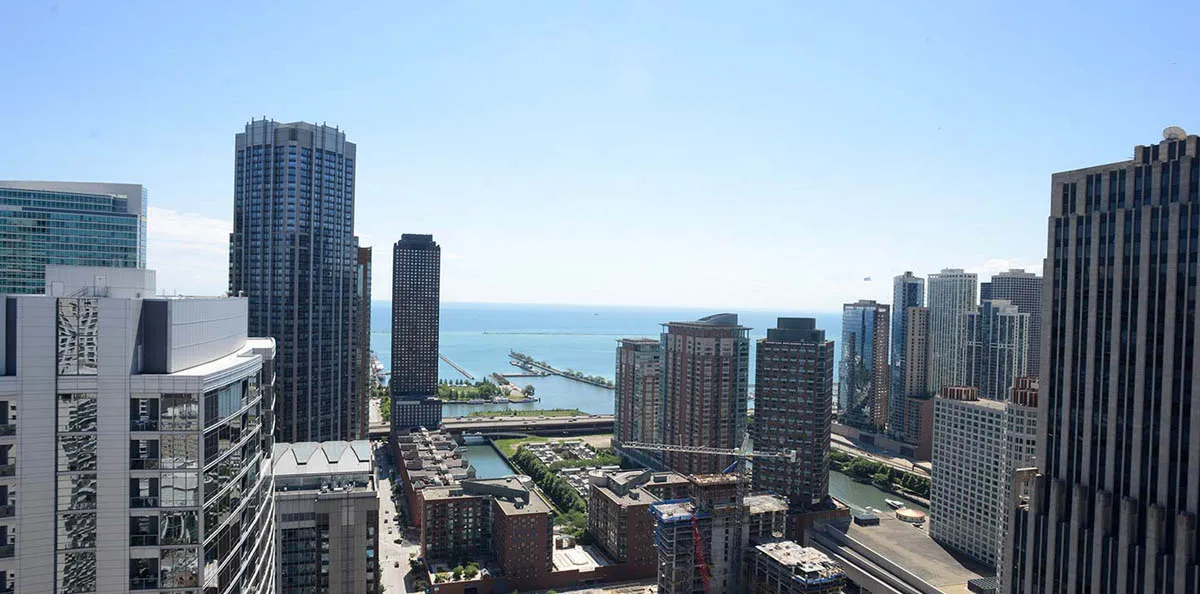 living room with wood floors and downtown view at Aston Chicago Apartments