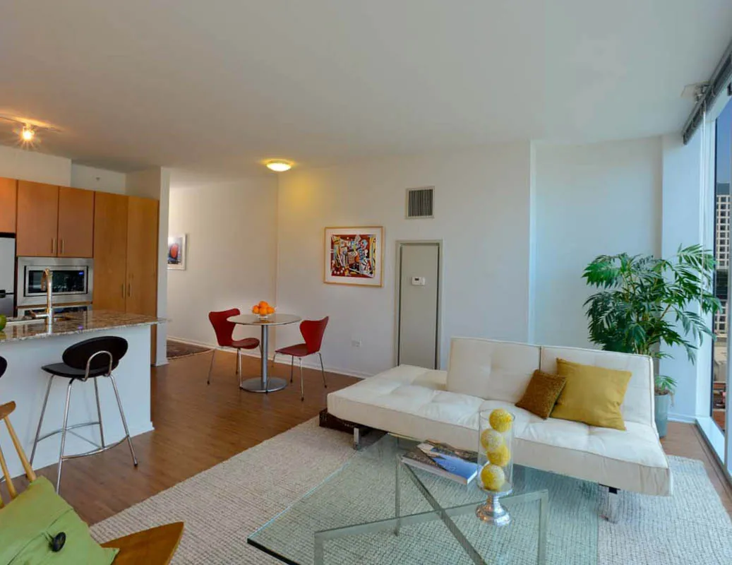 living room with wood floors and downtown view at Aston Chicago Apartments