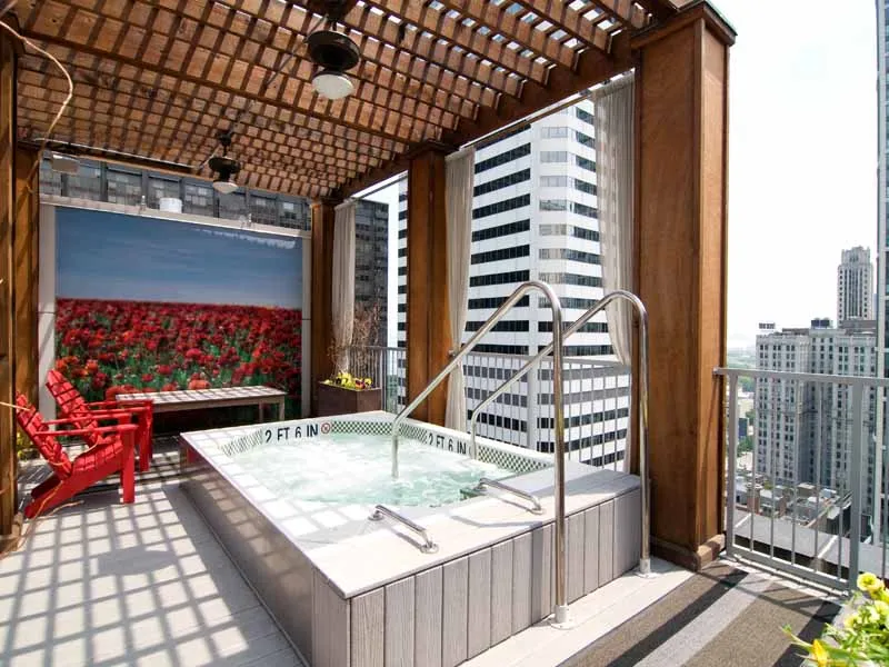 entrance to MDA City Club Apartments with red bench a flowers in pot