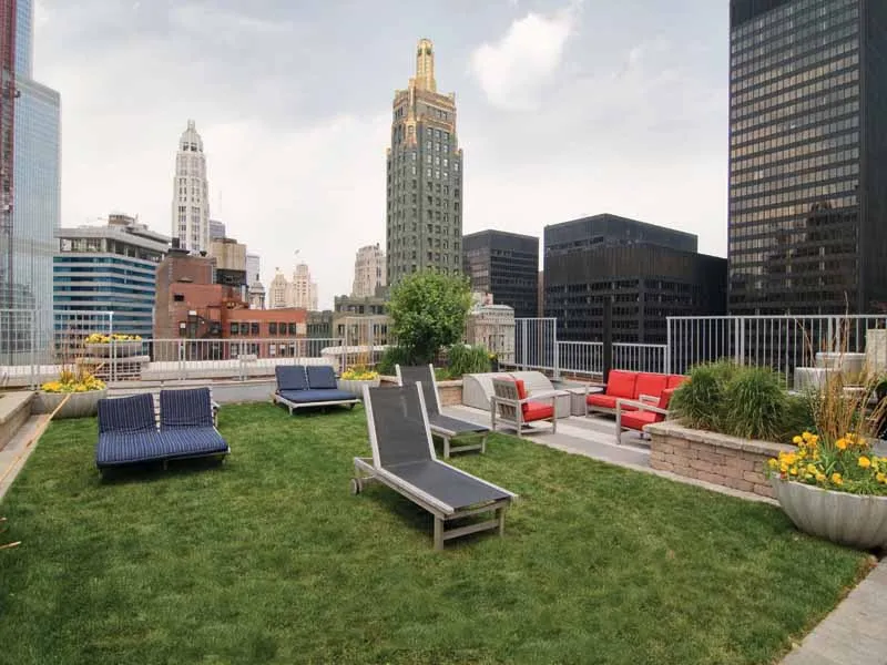 entrance to MDA City Club Apartments with red bench a flowers in pot