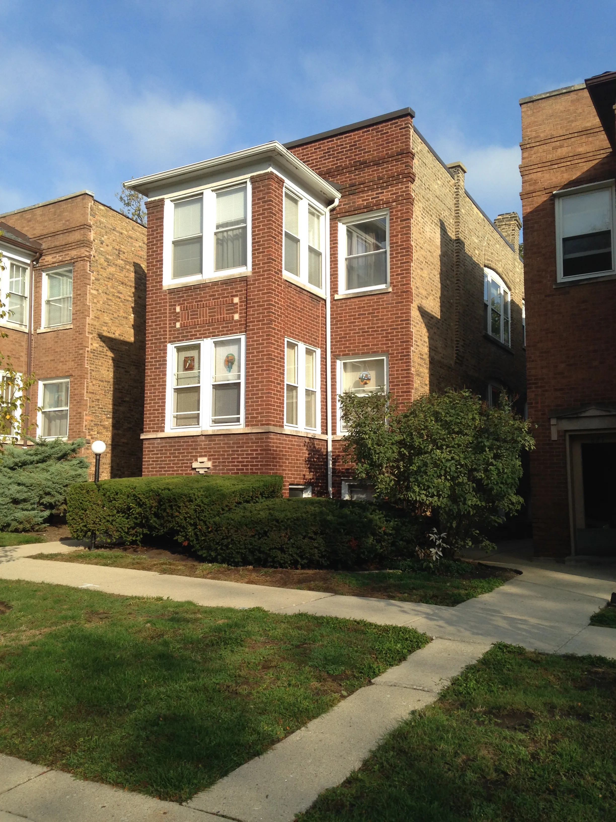 front view of whote frame windows and red brick- 815-833 Mulford Apartments