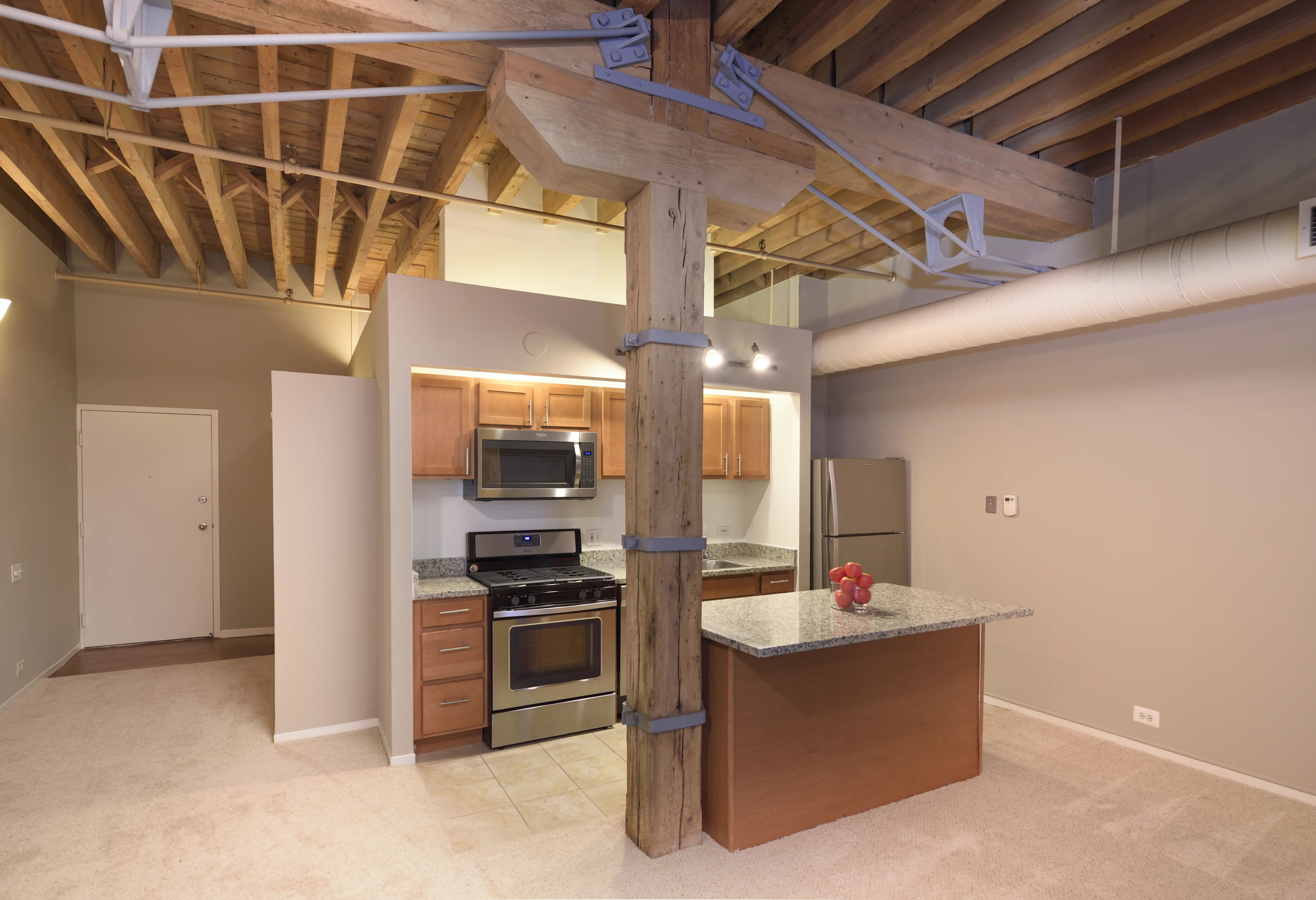 bedroom with exposed wood beam ceiling at Cobbler Square Lofts
