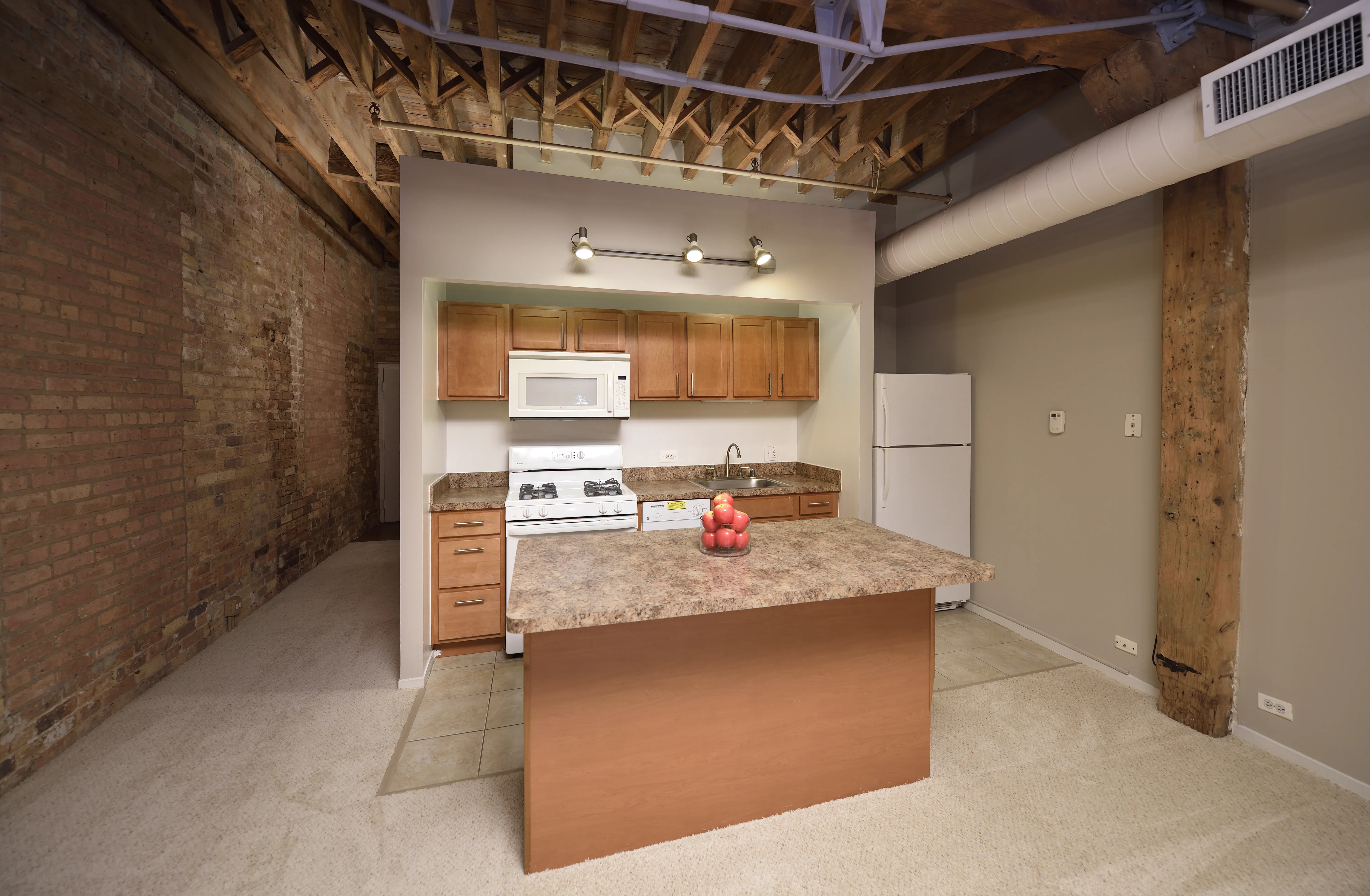 bedroom with exposed wood beam ceiling at Cobbler Square Lofts