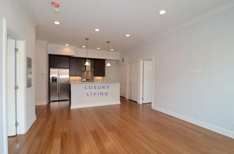 model kitchen and living room with wood floors at Huron Place Apartments