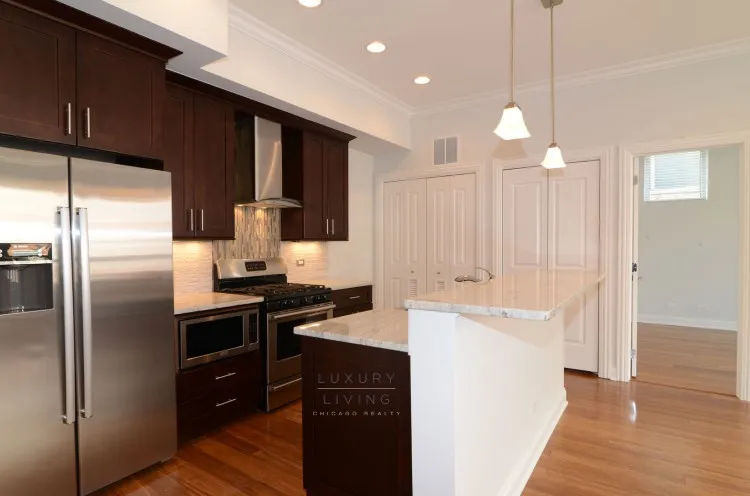 model kitchen and living room with wood floors at Huron Place Apartments