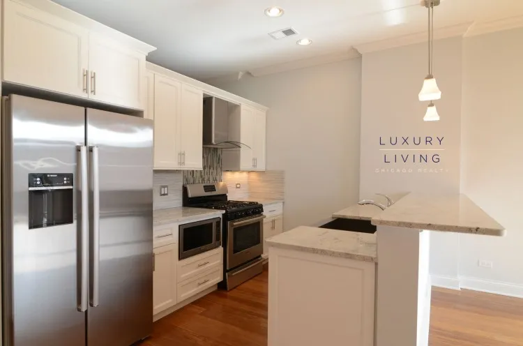 model kitchen and living room with wood floors at Huron Place Apartments