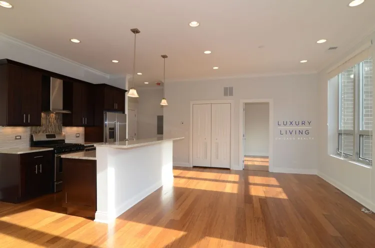 model kitchen and living room with wood floors at Huron Place Apartments