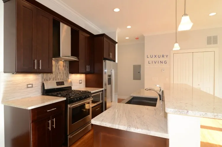 model kitchen and living room with wood floors at Huron Place Apartments