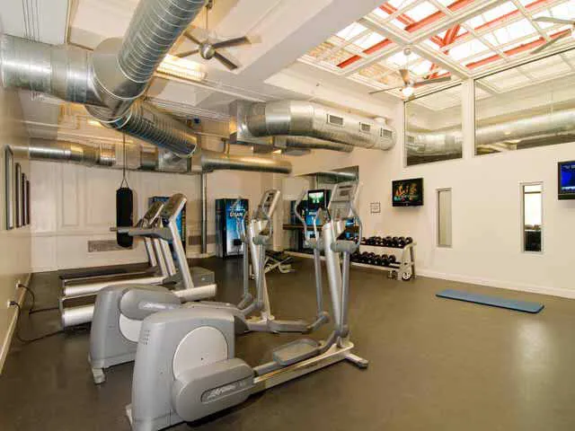 entrance to MDA City Club Apartments with red bench a flowers in pot