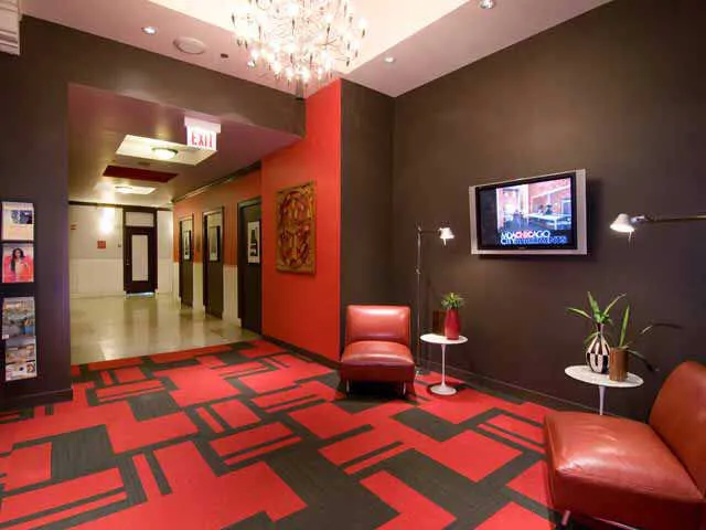 entrance to MDA City Club Apartments with red bench a flowers in pot