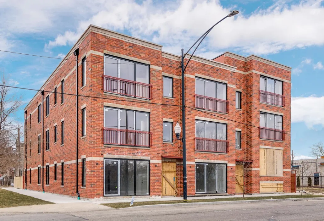 exterior of brick condo building in Chicago with retail space in ground floor