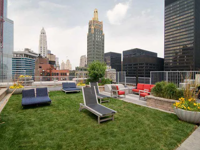 entrance to MDA City Club Apartments with red bench a flowers in pot