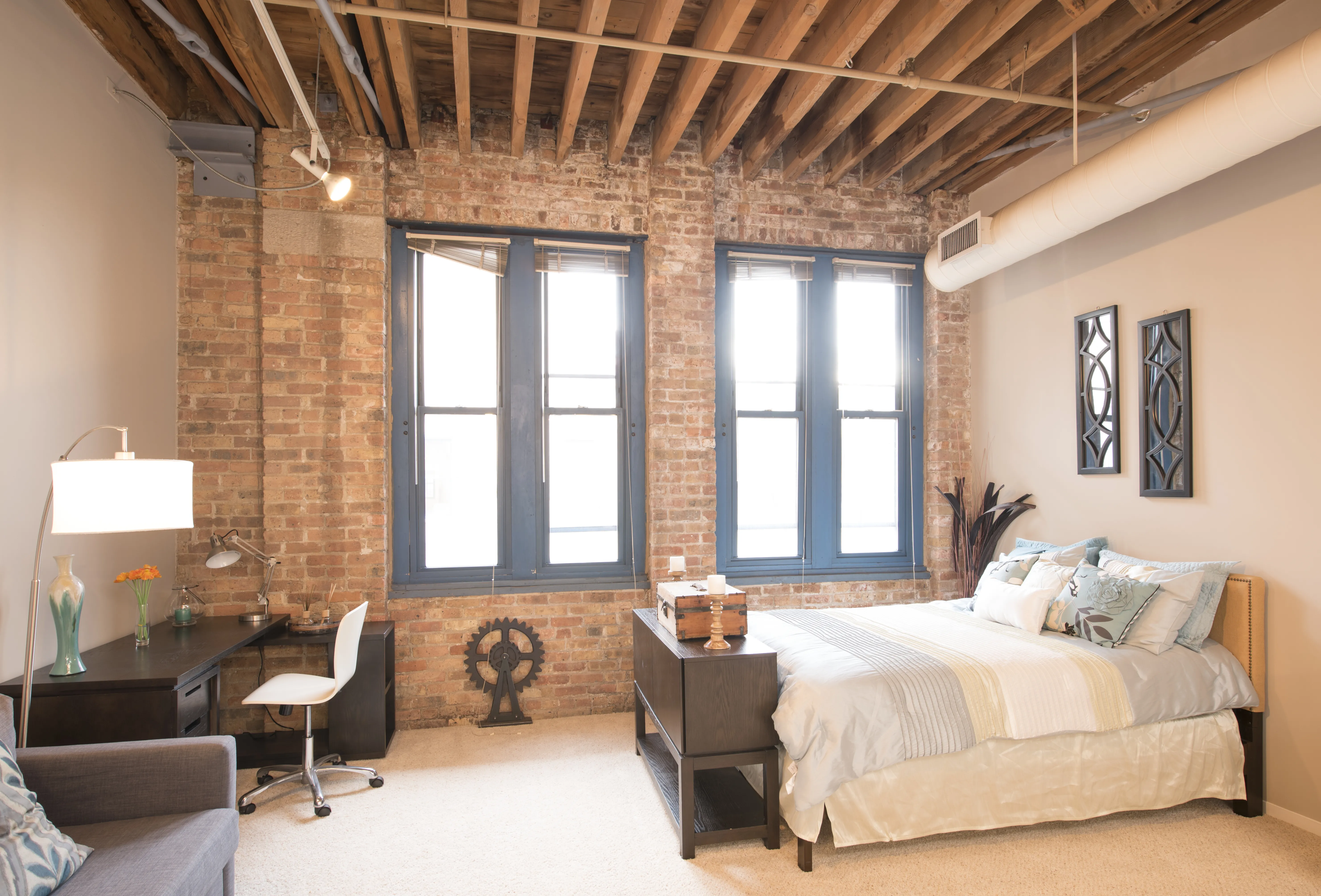 bedroom with exposed wood beam ceiling at Cobbler Square Lofts