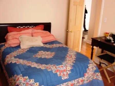 Queen size bed occupying 1/3 the bedroom walls note dresser on right