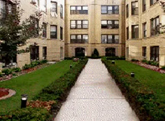 the grass and landscaped courtyard of The Dickens Courtyard Apartments