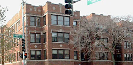 front red brick with windows and trees at 7000 North Sheridan Apartments