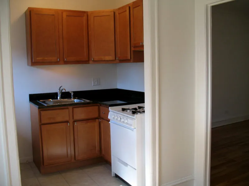 courtyard with trees, bushes and dark brick building at 921-929 W Oakdale