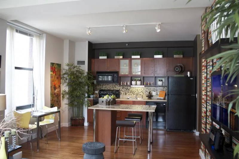 entrance to MDA City Club Apartments with red bench a flowers in pot